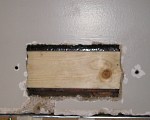 Wood furring strip installed into hole to hold drywall piece.