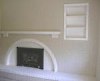 Brick fireplace painted along with a wood mantle and shelve.