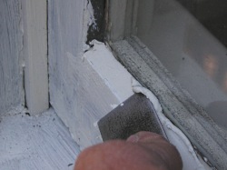 Applying glazing putty to wood windows.
