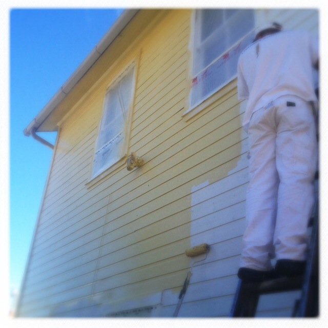 Painting the outside of a house yellow.
